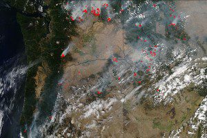 This natural-color satellite image was collected by the Moderate Resolution Imaging Spectroradiometer (MODIS) aboard NASA's Aqua satellite on Aug. 25, 2015. Actively burning areas, detected by MODIS' thermal bands, are outlined in red. (Credit: Jeff Schmaltz, MODIS Rapid Response Team)